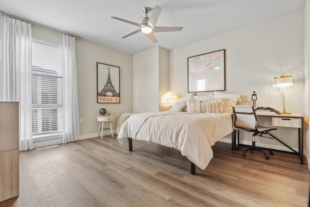 bedroom with ceiling fan and map on the wall